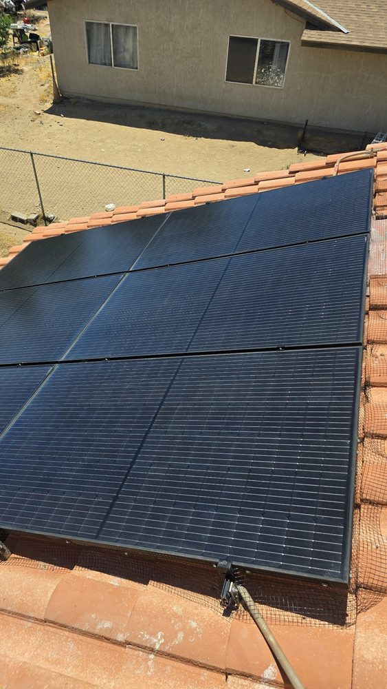 The same red-tile roof array after cleaning, panels dark and clear