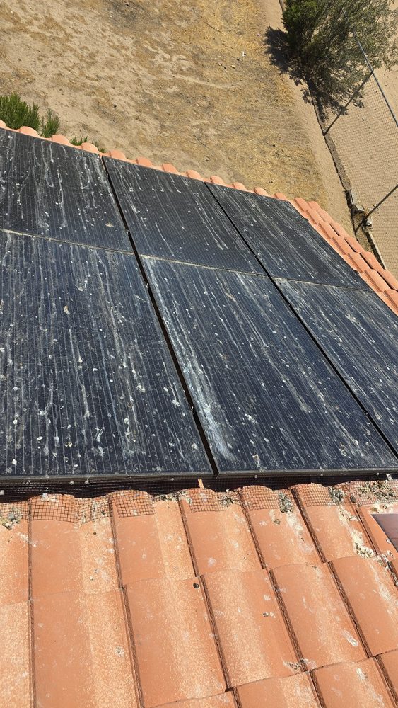 Solar panels caked in bird droppings and white streaks before cleaning